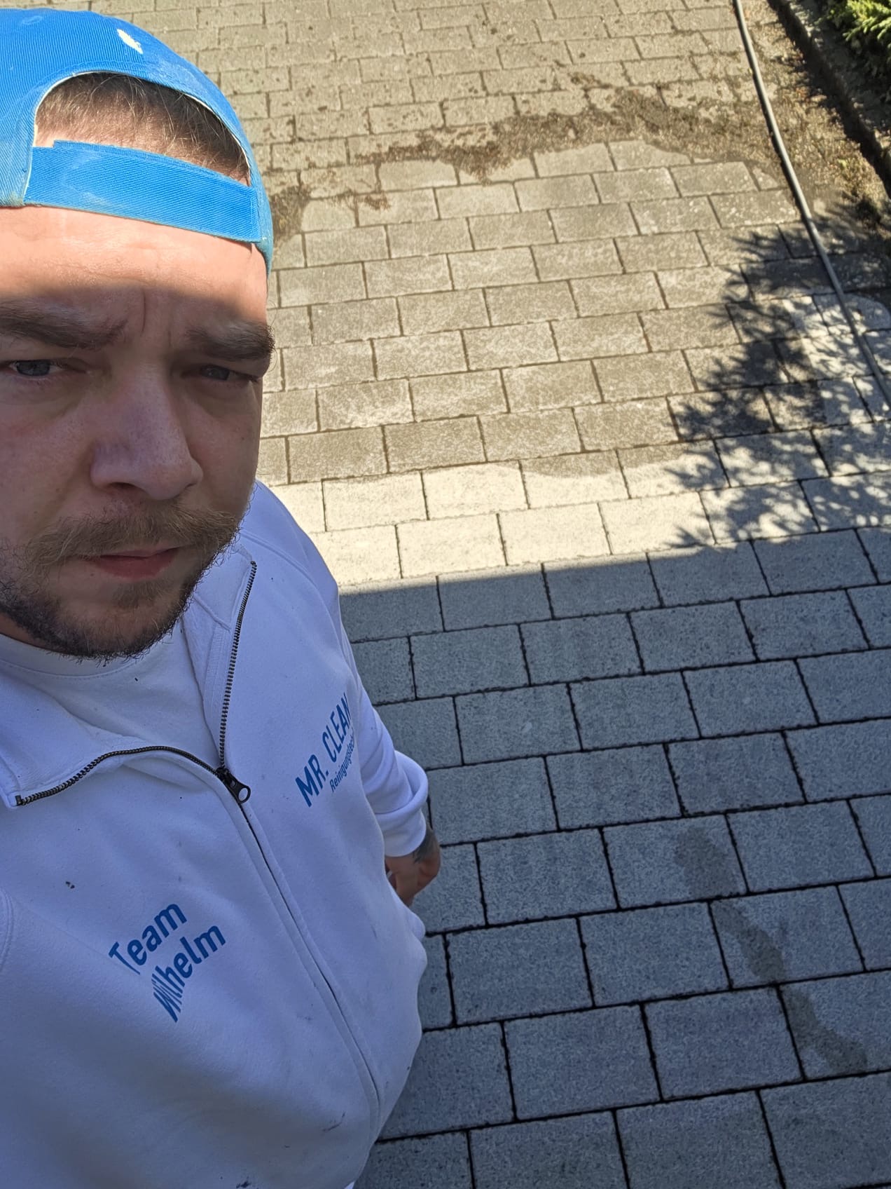 Mitarbeiter von Mr. Clean vor gereinigter Pflasterfläche